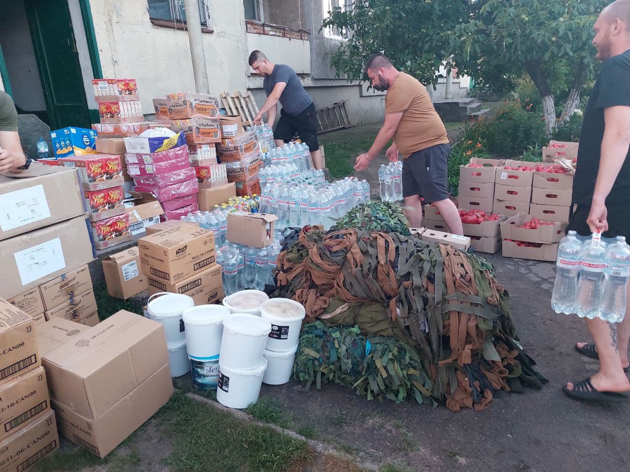 Volunteers sorting bottled water, food, and camouflage netting for delivery